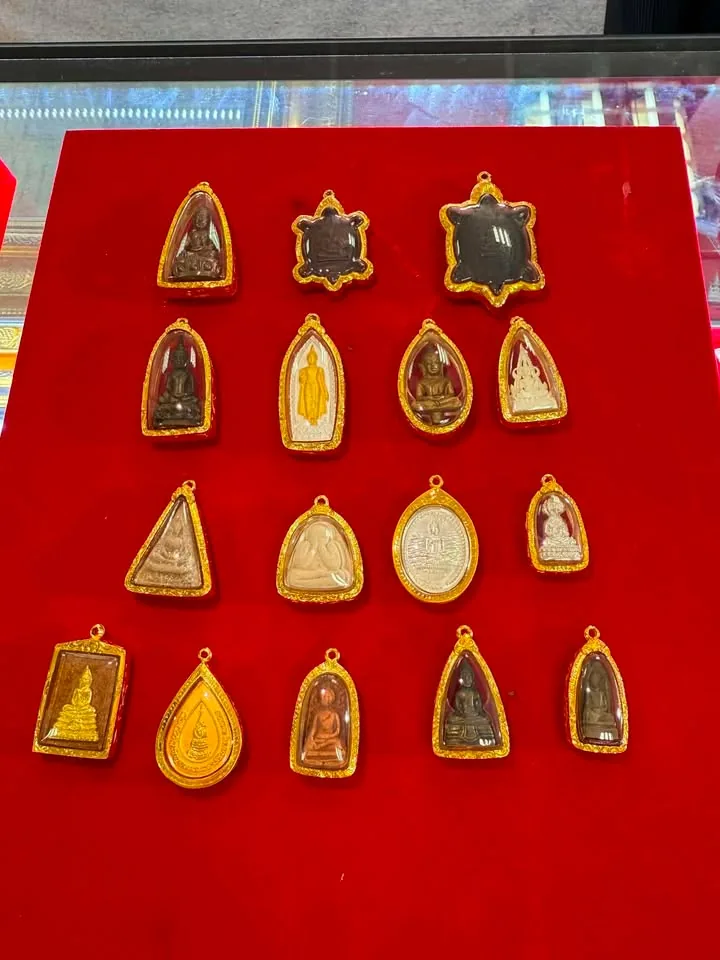 พระเลี่ยมกรอบทองหลายองค์บนแผงกำมะหยี่แดง