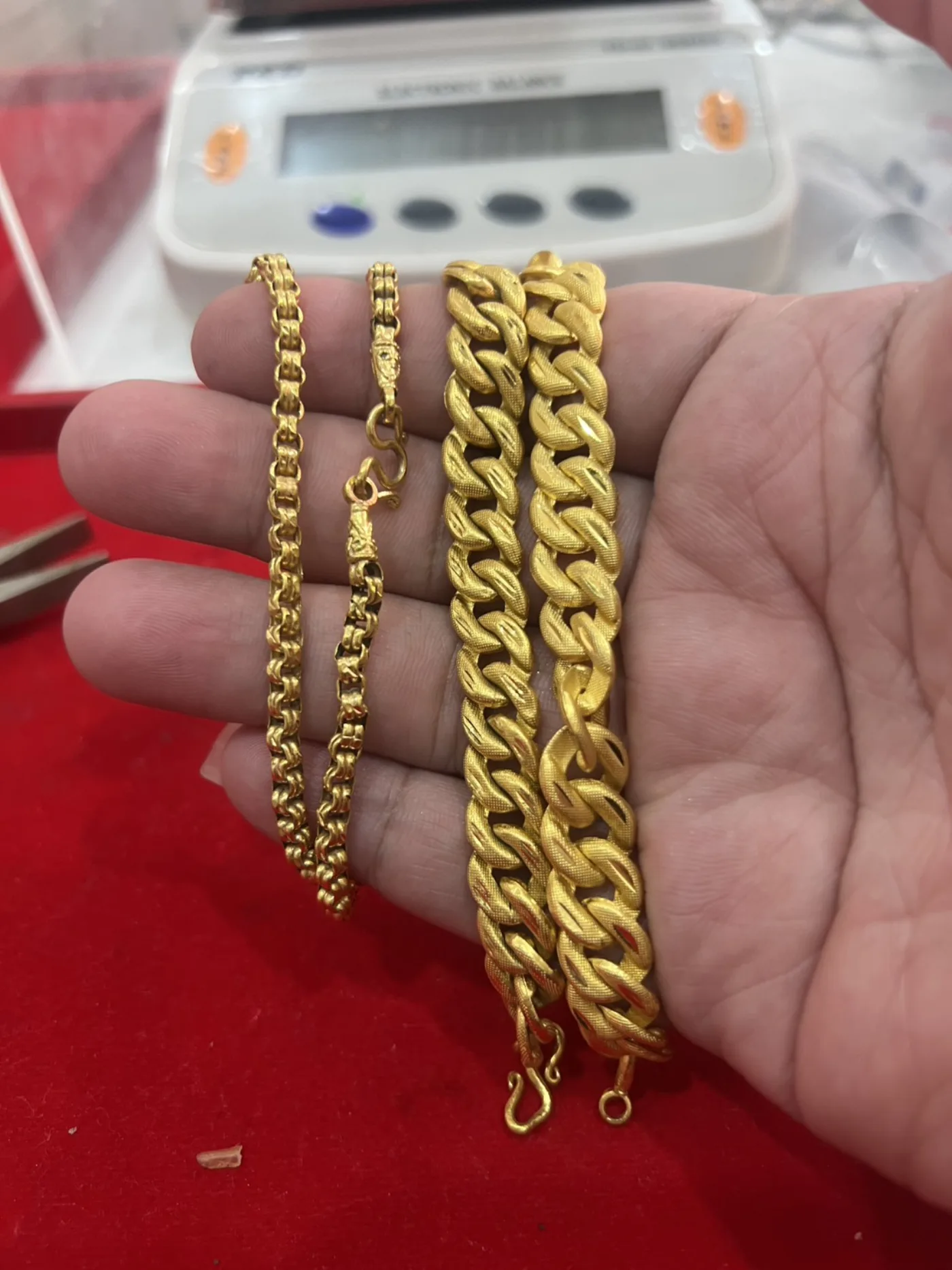 สร้อยคอทองคำที่ลูกค้านำมาขาย วางบนมือหน้าตาชั่งของร้าน